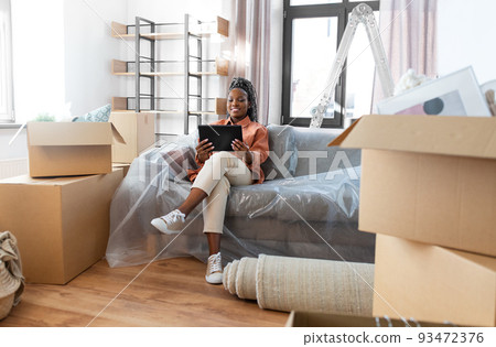 smiling woman with tablet pc moving into new home smiling woman with tablet pc moving into new home 93472376