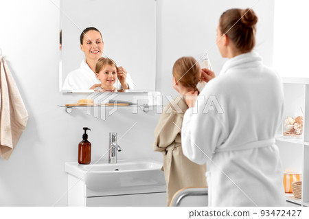 mother and daughter braiding hair in bathroom mother and daughter braiding hair in bathroom 93472427