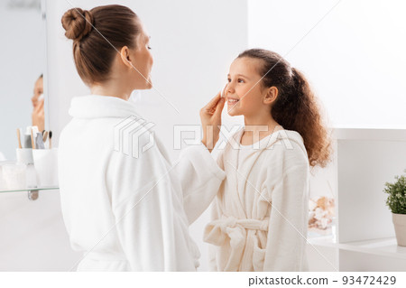 mother with cotton pad cleaning daughter's face mother with cotton pad cleaning daughter's face 93472429