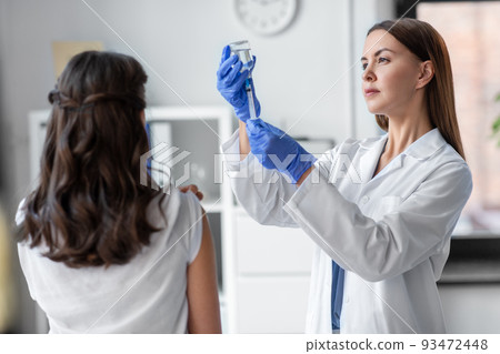 female doctor with syringe vaccinating patient female doctor with syringe vaccinating patient 93472448