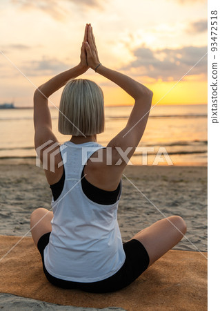 woman meditating in lotus pose on beach woman meditating in lotus pose on beach 93472518