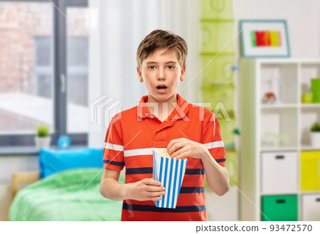 boy eating popcorn at home 93472570