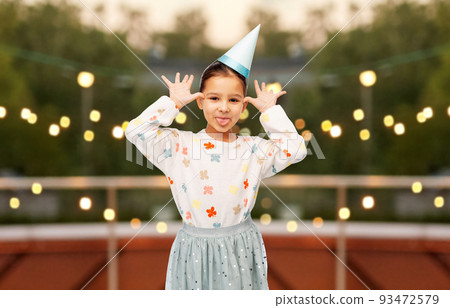 little girl in birthday party hat making faces little girl in birthday party hat making faces 93472579