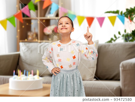 happy girl pointing finger up at birthday party happy girl pointing finger up at birthday party 93472580