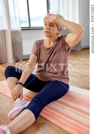 tired senior woman exercising on mat at home tired senior woman exercising on mat at home 93472663