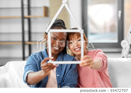 happy smiling women with ruler in shape of house 93472707