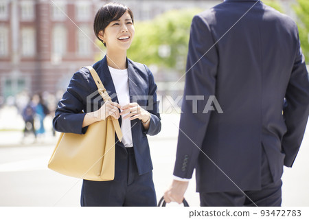 一位微笑的女商人與一位商人交談 93472783