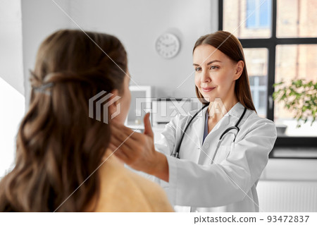 doctor checking lymph nodes of woman at hospital 93472837