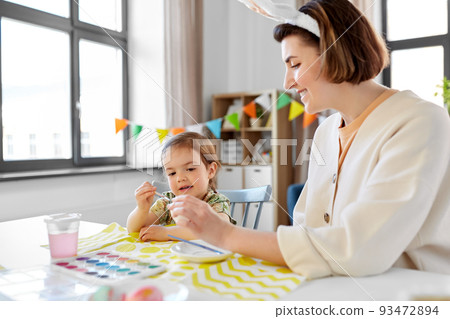 mother with child coloring easter eggs at home mother with child coloring easter eggs at home 93472894