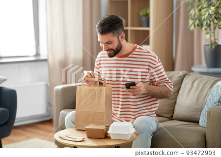 man with phone checking food order at home man with phone checking food order at home 93472903