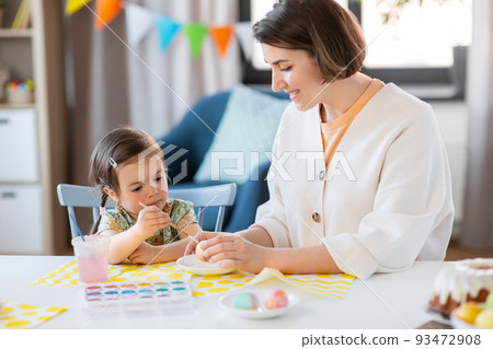 mother with child coloring easter eggs at home mother with child coloring easter eggs at home 93472908