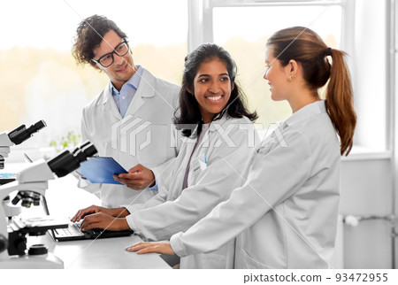 scientists with microscopes working in laboratory 93472955