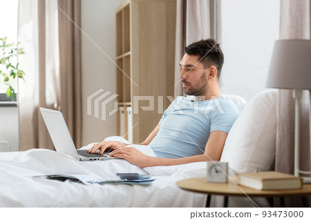 man with laptop in bed at home bedroom man with laptop in bed at home bedroom 93473000