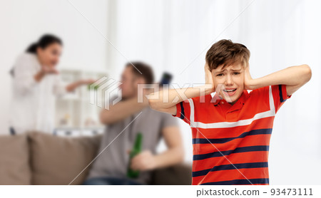 boy closing ears with hands over parents fighting 93473111