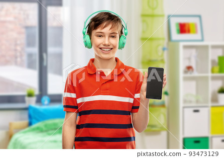 boy in headphones listening to music on smartphone 93473129