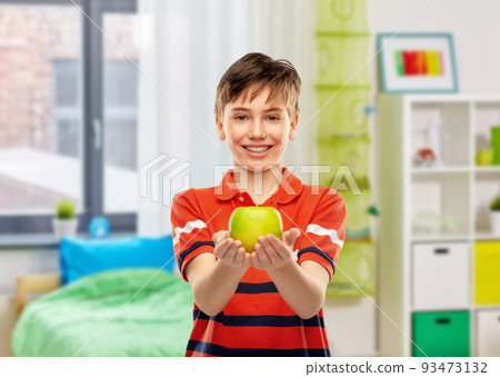 happy smiling boy holding green apple at home happy smiling boy holding green apple at home 93473132
