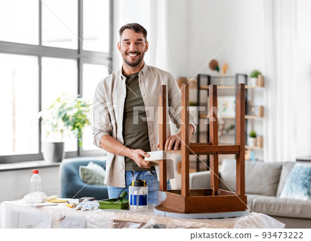 man sticking adhesive tape to table for repainting 93473222