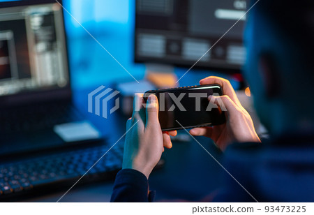 hacker with smartphone and computers in dark room hacker with smartphone and computers in dark room 93473225