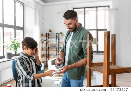 father treats son's injured finger with antiseptic father treats son's injured finger with antiseptic 93473227