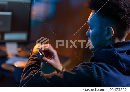 hacker with smart watch and computers in dark room hacker with smart watch and computers in dark room 93473232
