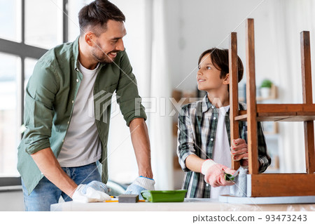 father and son painting old table in grey color father and son painting old table in grey color 93473243