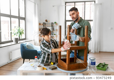 father and son cleaning old table with tissue 93473249