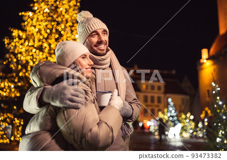 happy couple with tea cups over christmas lights happy couple with tea cups over christmas lights 93473382