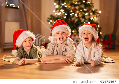happy children in santa hats on christmas at home 93473467