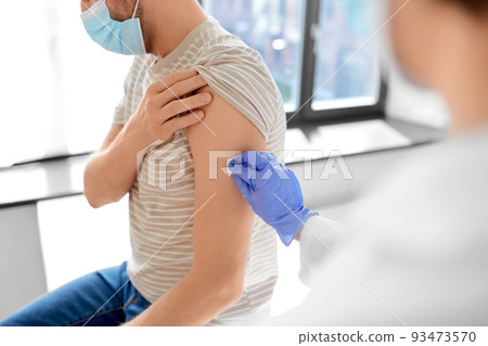 doctor disinfecting patient's skin for vaccination doctor disinfecting patient's skin for vaccination 93473570