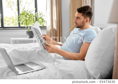 man with laptop working in bed at home bedroom man with laptop working in bed at home bedroom 93473630