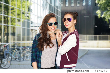 smiling teenage girls in sunglasses on city street 93473717