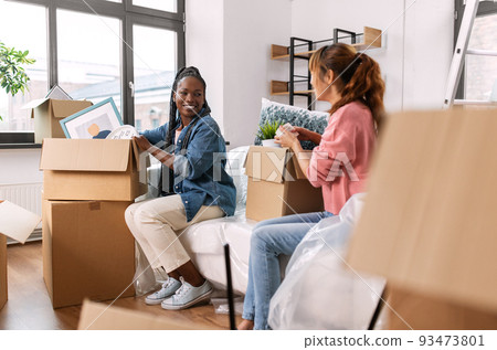 women unpacking boxes and moving to new home 93473801