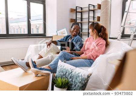 women with tablet pc moving to new home 93473802