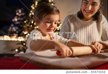 mother and daughter making gingerbread at home 93473838