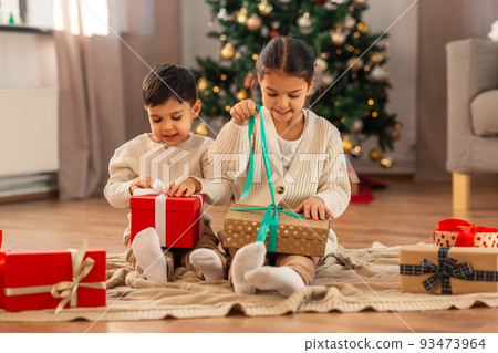 happy children opening christmas gifts at home 93473964