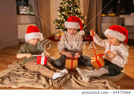 happy children opening christmas gifts at home 93473966