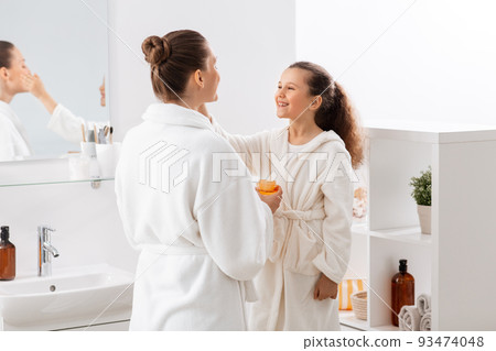 mother and daughter with moisturizer at bathroom 93474048