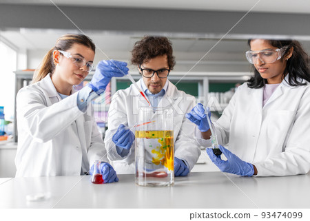 scientists with chemicals working in laboratory 93474099