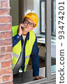 builder looking out window and calling on phone 93474201