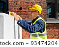 male builder with level measuring wall 93474204