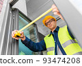 male builder with ruler measuring window 93474208