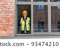 builder with smartphone taking picture at window 93474210