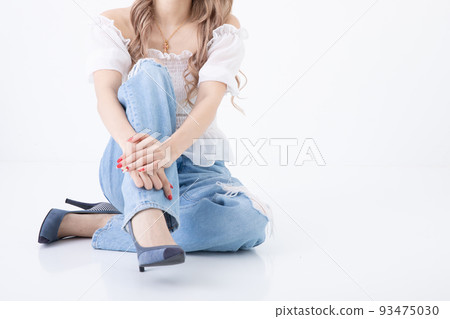 A blonde woman sitting with her legs crossed A blonde woman sitting with her legs crossed 93475030