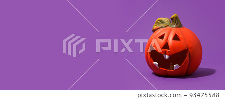 Jack-o-lantern, pumpkin toy for Halloween on purple background. Plastic pumpkin, trick or treat, seasonal celebration. Traditional autumn holiday decor, Copy space, banner 93475588