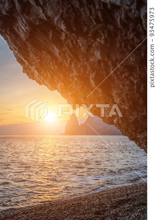 View of the sunset sea and the beach, the volcanic rock, sand and pebbles, volcanic basalt as in Iceland. Copy space. The concept of calmness, silence and unity with nature. Fiolent Sevastopol, Crimea 93475973