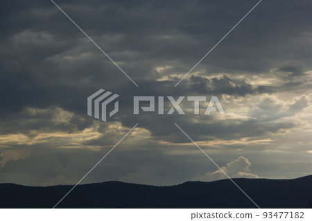 Sunset and clouds on a dark background of mountains Sunset and clouds on a dark background of mountains 93477182