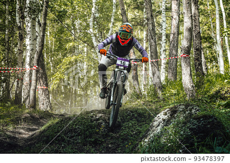 athlete rider riding forest trail in downhill race 93478397