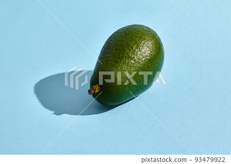 Close up high quality image of whole avocado, fruit composition on blue pastel Close up high quality image of whole avocado, fruit composition on blue pastel 93479922