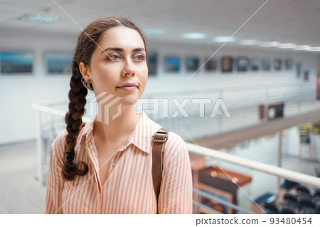 Portrait of young pretty caucasian woman contemplating at the artwork. Exhibition in the art gallery. Excursion and visit to the museum Portrait of young pretty caucasian woman contemplating at the artwork. Exhibition in the art gallery. Excursion and visit to the museum 93480454