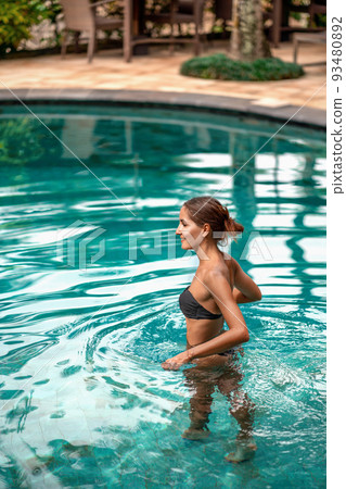 Caucasian girl bathing outside in the pool 93480892